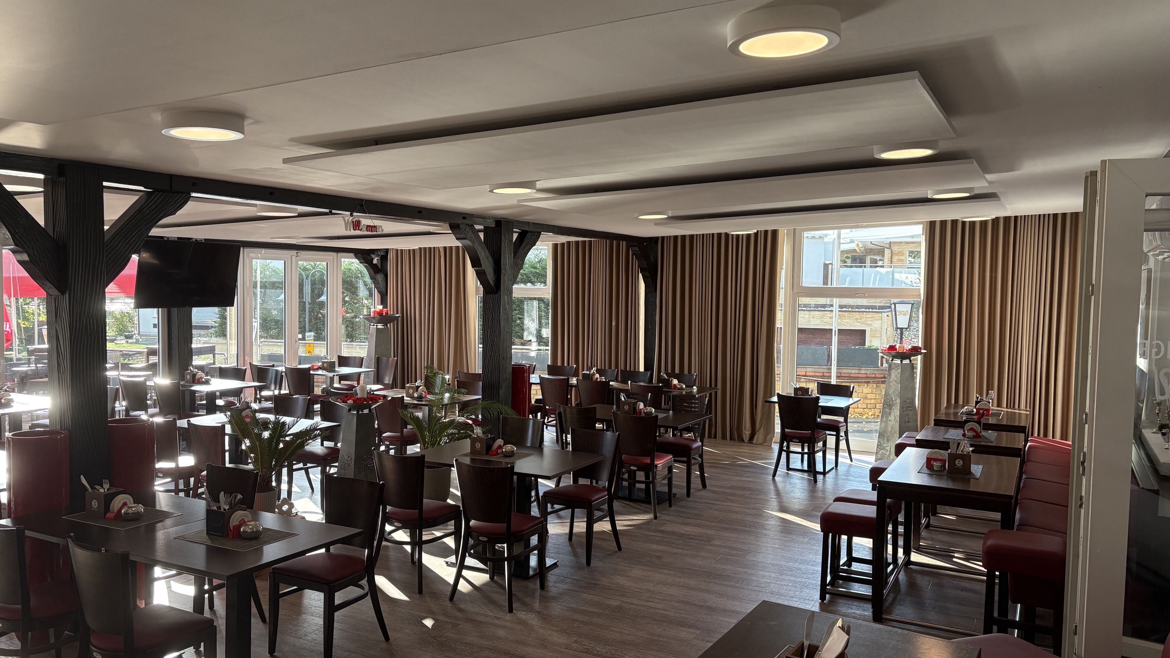 Gastraum von Restaurant Schlimgen mit Holztischen und Blick zur Terrasse